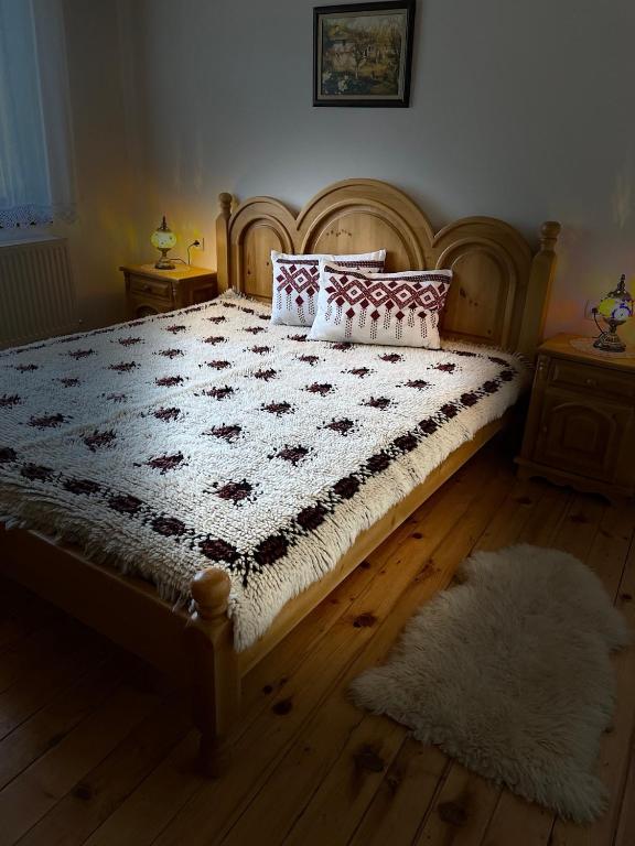 a bedroom with a large bed with a wooden headboard at Музикалната къща in Breze