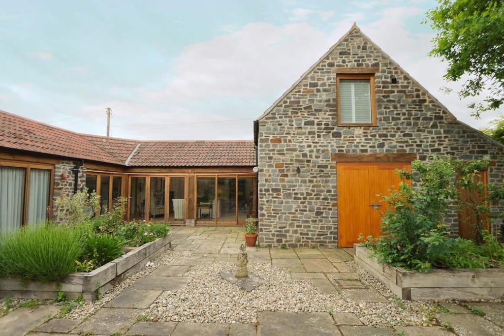 an exterior view of a brick house with a garage at Musthay Mews Tockington cottage in Bristol