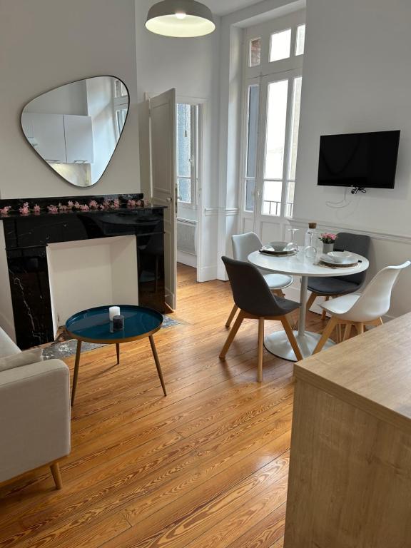 - un salon avec une table, des chaises et un miroir dans l'établissement Le Toulousain 101 - Appartement Calme en Hypercentre - Quartier Jeanne d'Arc, à Toulouse