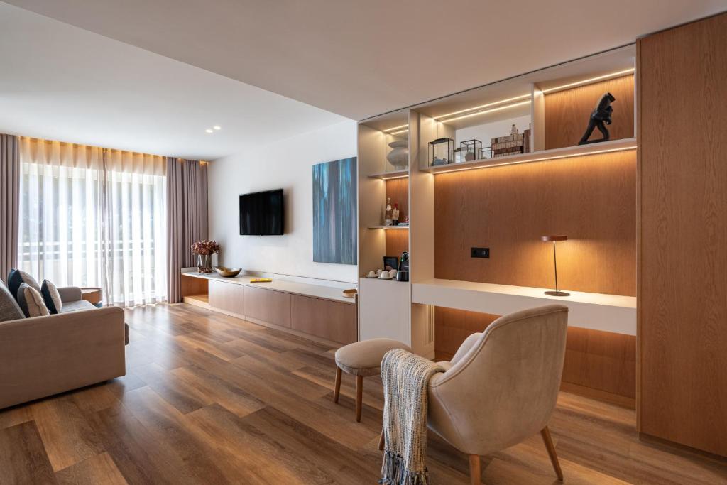 a living room with a couch and a chair at Onyria Quinta da Marinha Hotel in Cascais