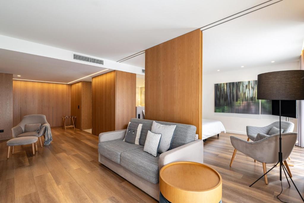 a living room with a couch and a bedroom at Onyria Quinta da Marinha Hotel in Cascais