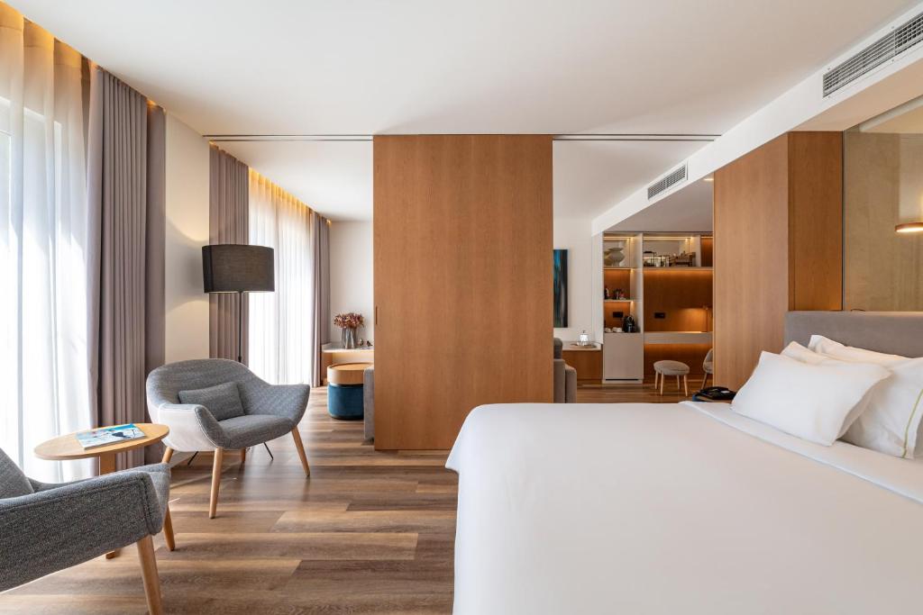 a hotel room with a bed and a chair at Onyria Quinta da Marinha Hotel in Cascais