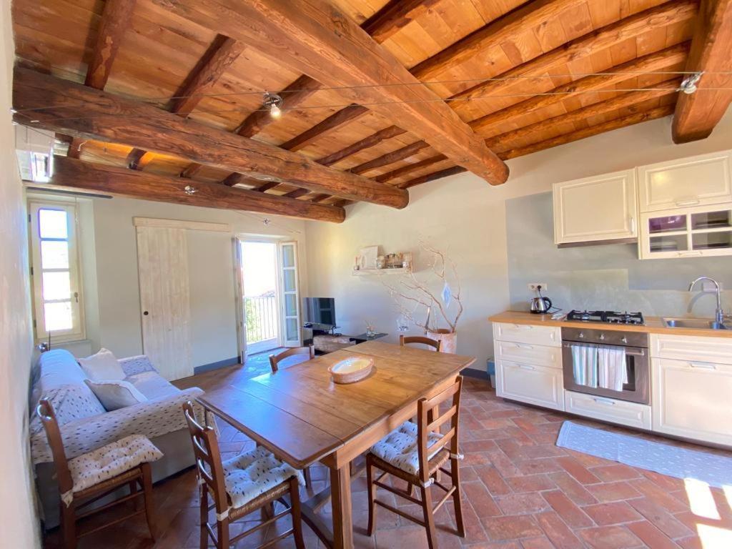 a living room with a wooden table and a kitchen at Alloro 6 in Marciana Marina