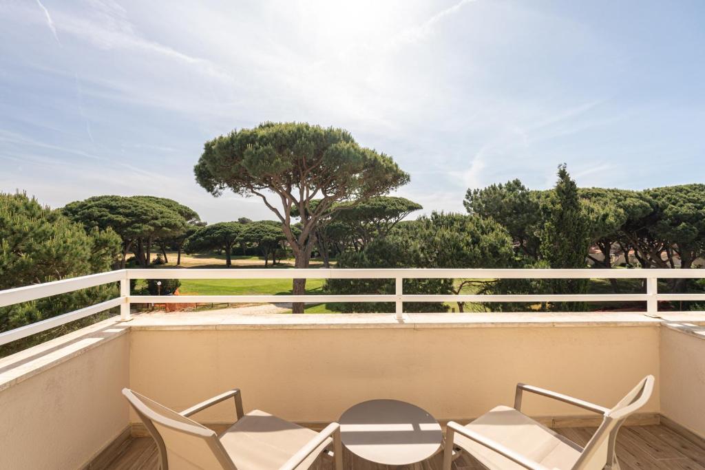 a balcony with chairs and a view of trees at Onyria Quinta da Marinha Hotel in Cascais