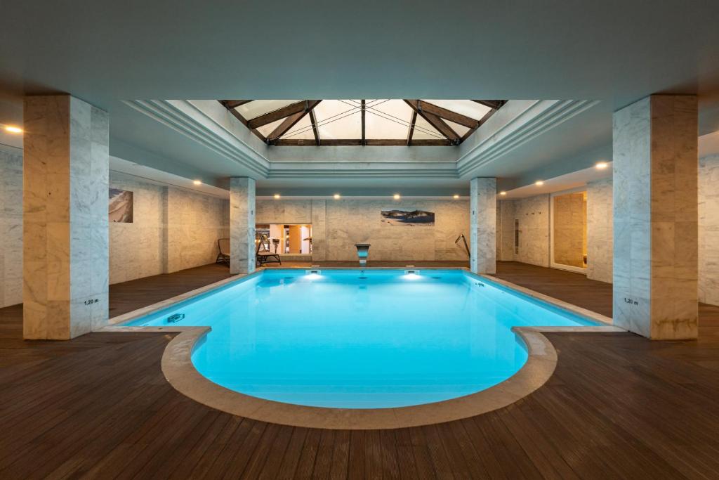 a large swimming pool in a building with a ceiling at Onyria Quinta da Marinha Hotel in Cascais