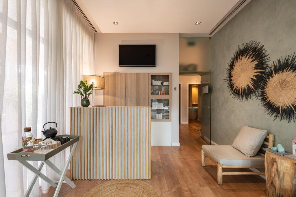 a living room with a television on a wall at Onyria Quinta da Marinha Hotel in Cascais