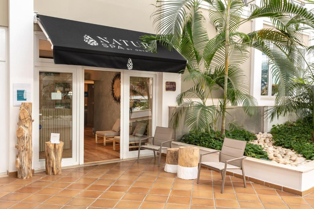 a restaurant with a black awning on a building at Onyria Quinta da Marinha Hotel in Cascais