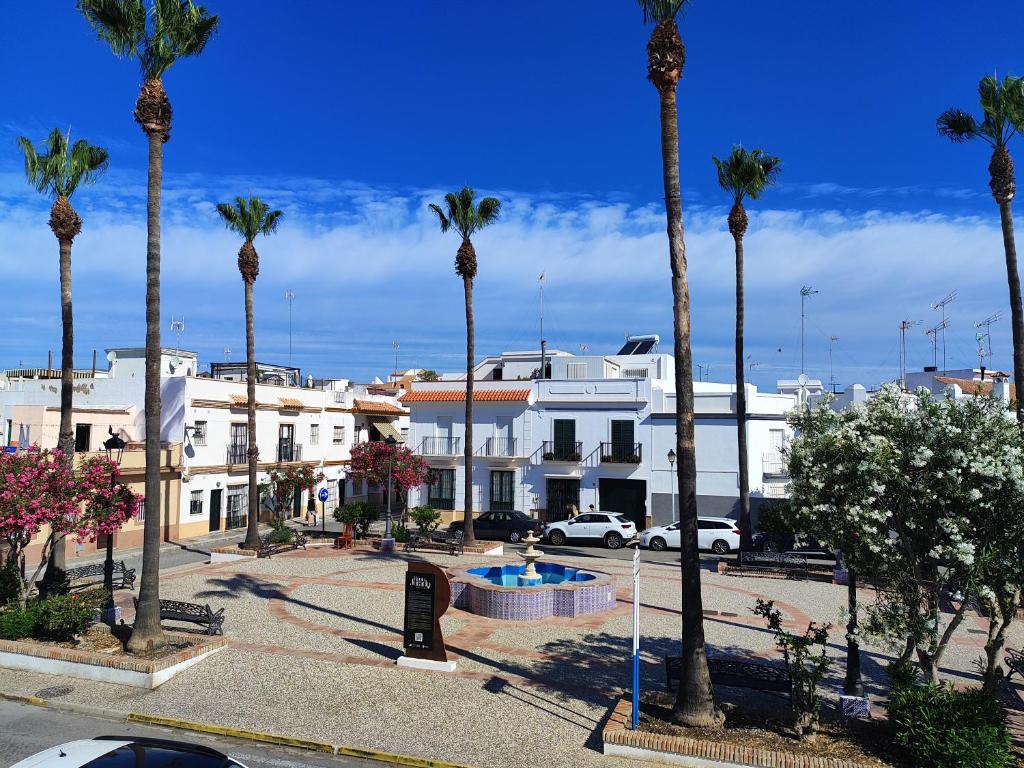 a group of palm trees in front of a building at La Longuera - Playa Cruz del Mar in Chipiona