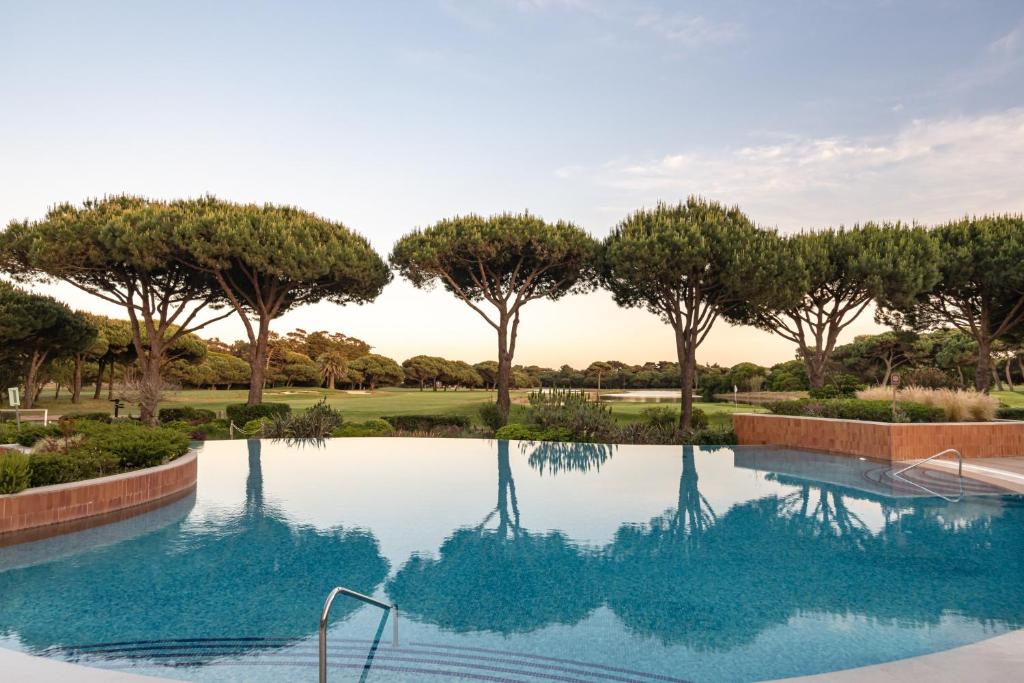a swimming pool with trees in the background at Onyria Quinta da Marinha Hotel in Cascais