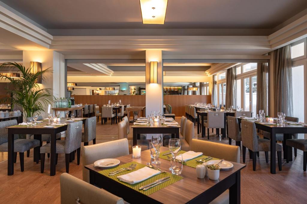a dining room with tables and chairs in a restaurant at Onyria Quinta da Marinha Hotel in Cascais