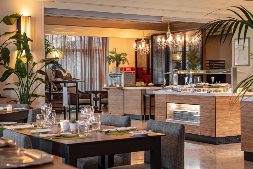 a restaurant with tables and chairs and a kitchen at Onyria Quinta da Marinha Hotel in Cascais