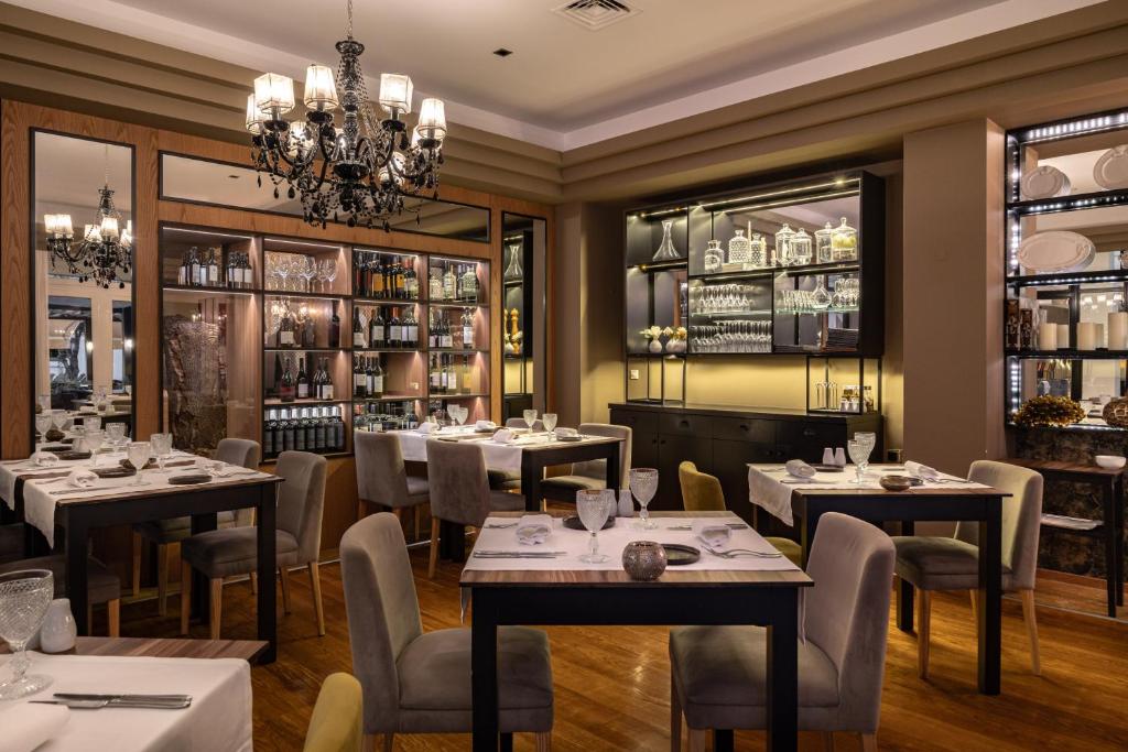 a restaurant with tables and chairs and a chandelier at Onyria Quinta da Marinha Hotel in Cascais