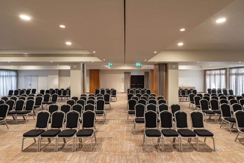 an empty room with chairs and a stage in the background at Onyria Quinta da Marinha Hotel in Cascais