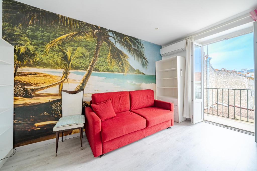 - un canapé rouge dans une pièce ornée d'une fresque murale de palmiers dans l'établissement 2P hyper-centre Nice, à Nice