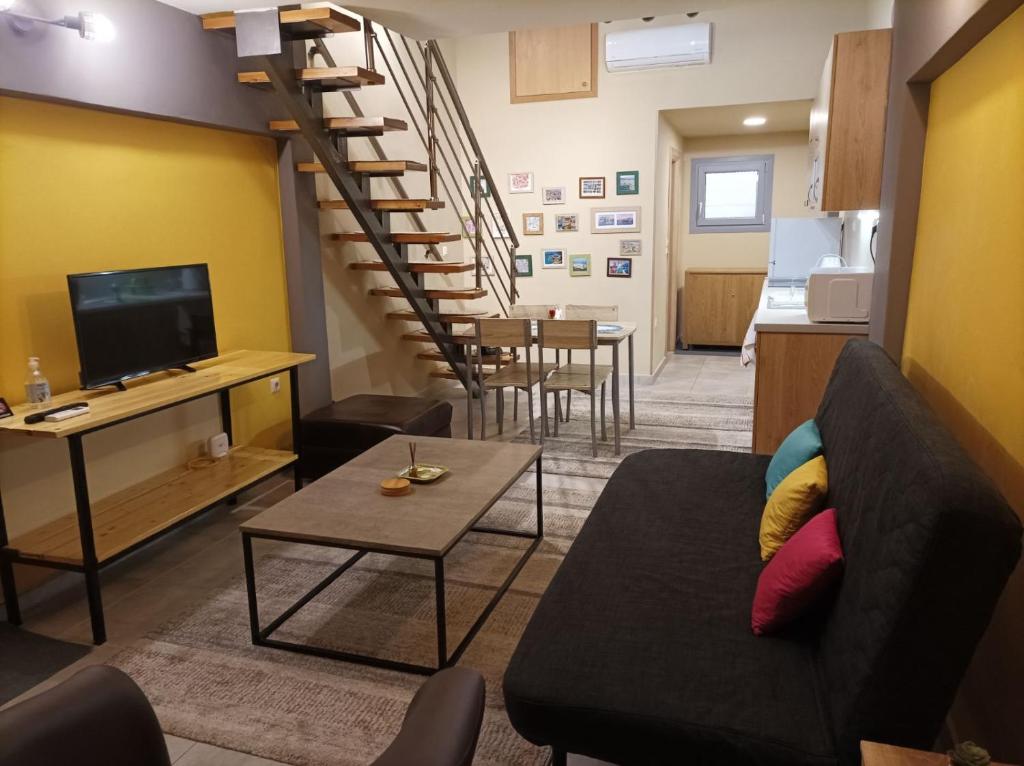 a living room with a couch and a staircase at The Urbanite in Kavála