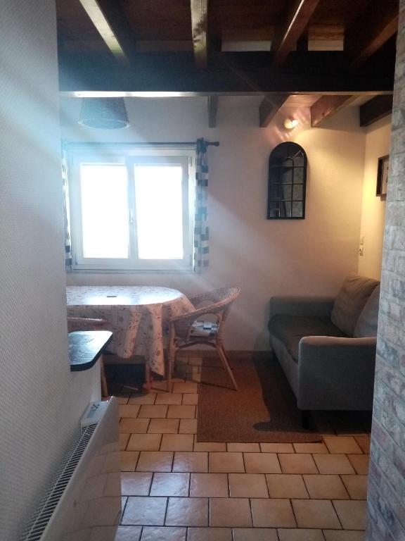 un salon avec un canapé et une table dans l'établissement Le Randonneur, à Chastreix