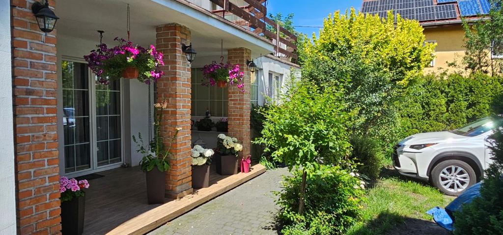 a car parked outside of a house with flowers at Kalina in Łeba