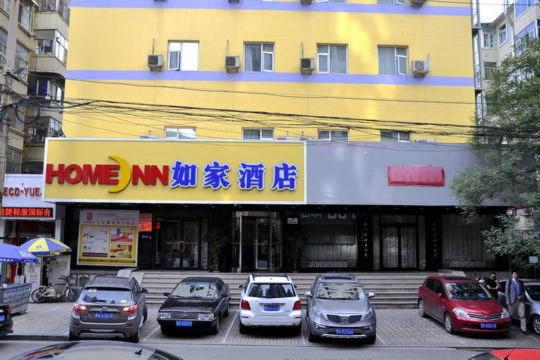ein Gebäude mit Autos auf einem Parkplatz in der Unterkunft Home Inn Taiyuan Liuxiang Pedestrian Street in Taiyuan
