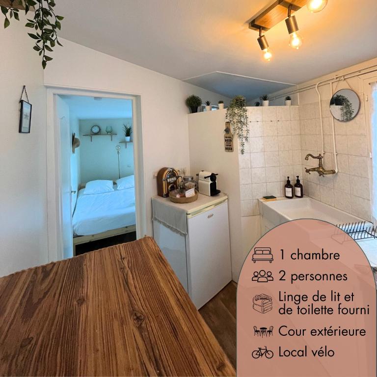 une cuisine avec une table et une chambre avec un lit dans l'établissement Le petit abri de la Garenne - Séjour cosy à Blois, à Blois