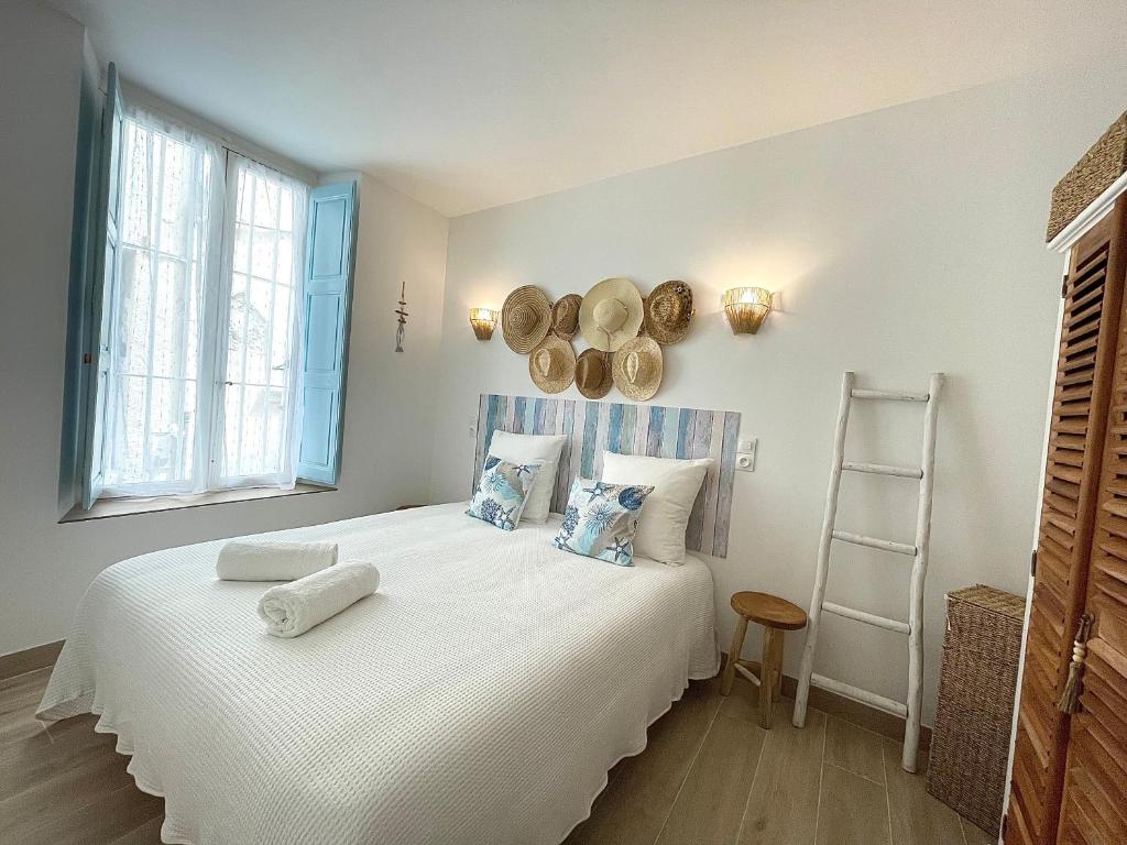 une chambre avec un grand lit blanc avec des serviettes dessus dans l'établissement Escale Romana, à La Ciotat