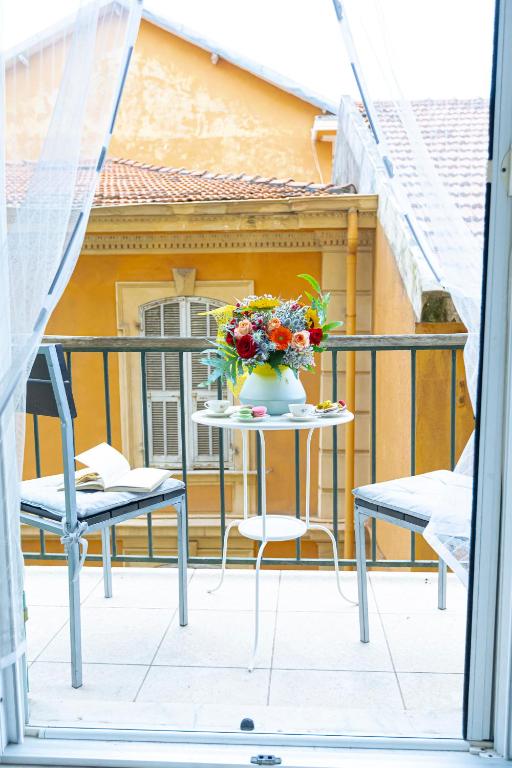 a table with a vase of flowers on a balcony at Ad un Passo dal Sole by Le Case di Tati in Sanremo