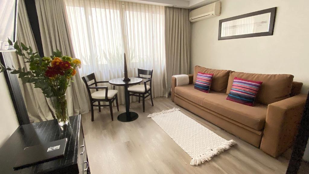 a living room with a couch and a table at Ulises Recoleta Suites in Buenos Aires