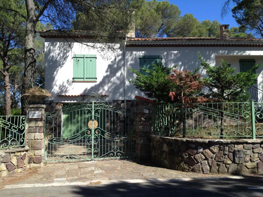 une porte devant une maison blanche avec une porte verte dans l'établissement Les cigales, à Fréjus