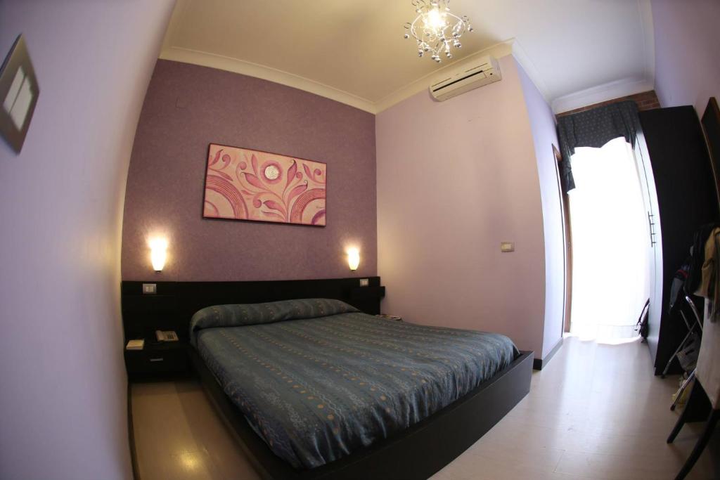 1 dormitorio con 1 cama y una pintura en la pared en Hotel Nettuno, en Nápoles