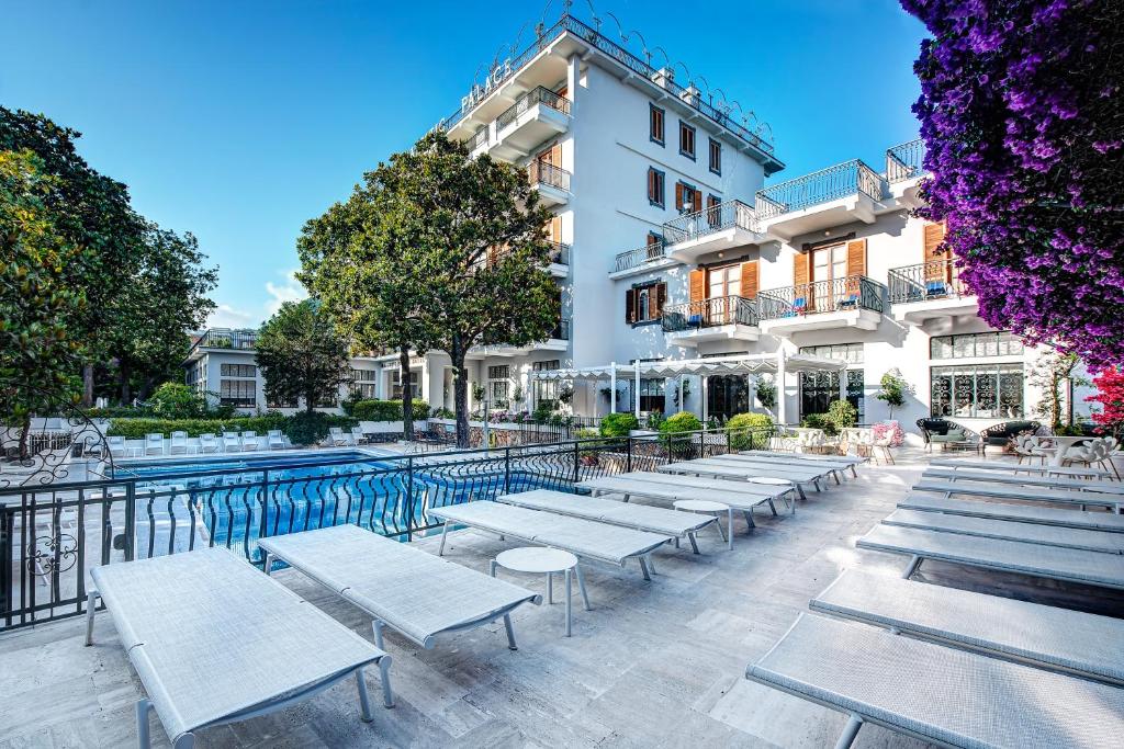 a row of white benches in front of a building at Majestic Palace Hotel in Sant'Agnello