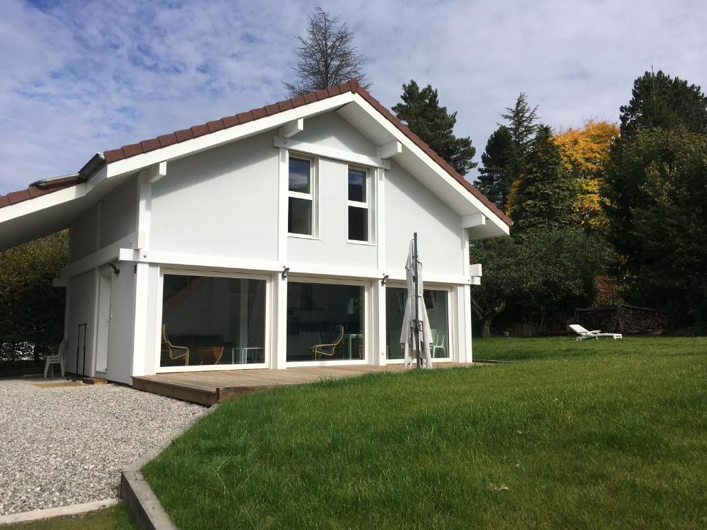Cette maison blanche dispose d'une grande fenêtre. dans l'établissement Maison FONGRAIN, à Annecy