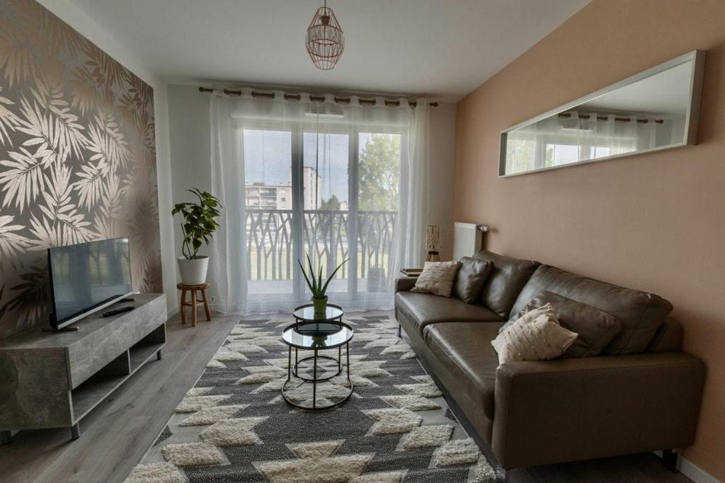 un salon avec un canapé et une télévision dans l'établissement Appartement passage à 10 mins de Charles De Gaulle, proche parc d'exposition, à Villepinte