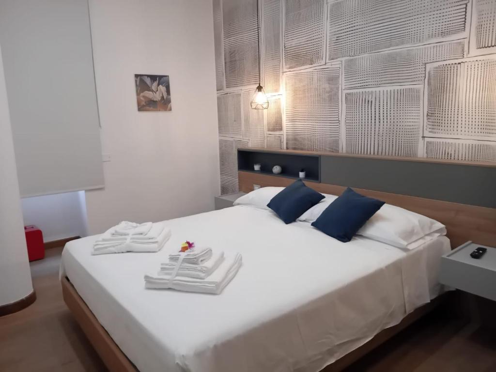 a bedroom with a large white bed with blue pillows at Antico Palazzo in Salerno