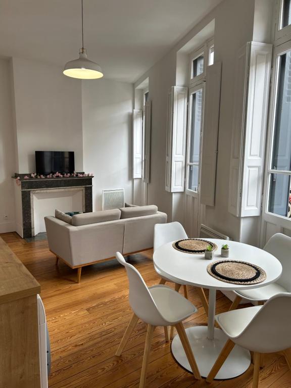 un salon avec un canapé, une table et des chaises dans l'établissement Le Toulousain 102 - Appartement Cosy en Hypercentre - Quartier Jeanne d'Arc, à Toulouse