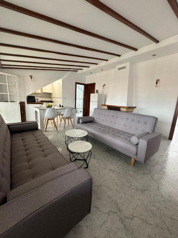 a living room with two couches and a table at Ático en el Centro de Cambados in Cambados
