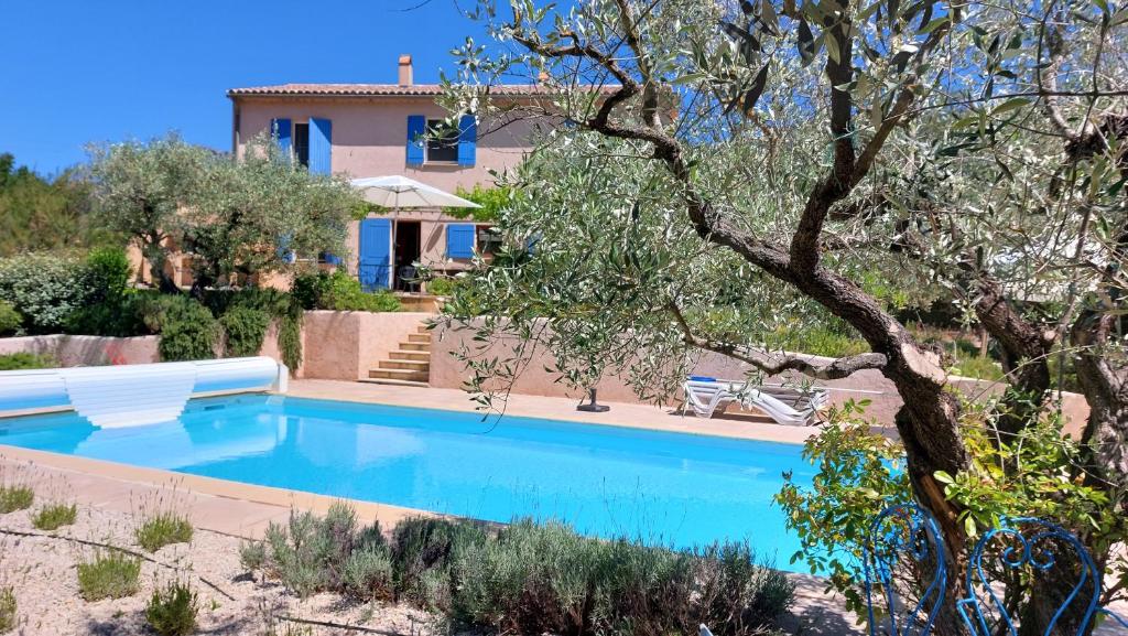 a villa with a swimming pool in front of a house at Freundliches Haus mit Pool und großem Garten in Buis-les-Baronnies