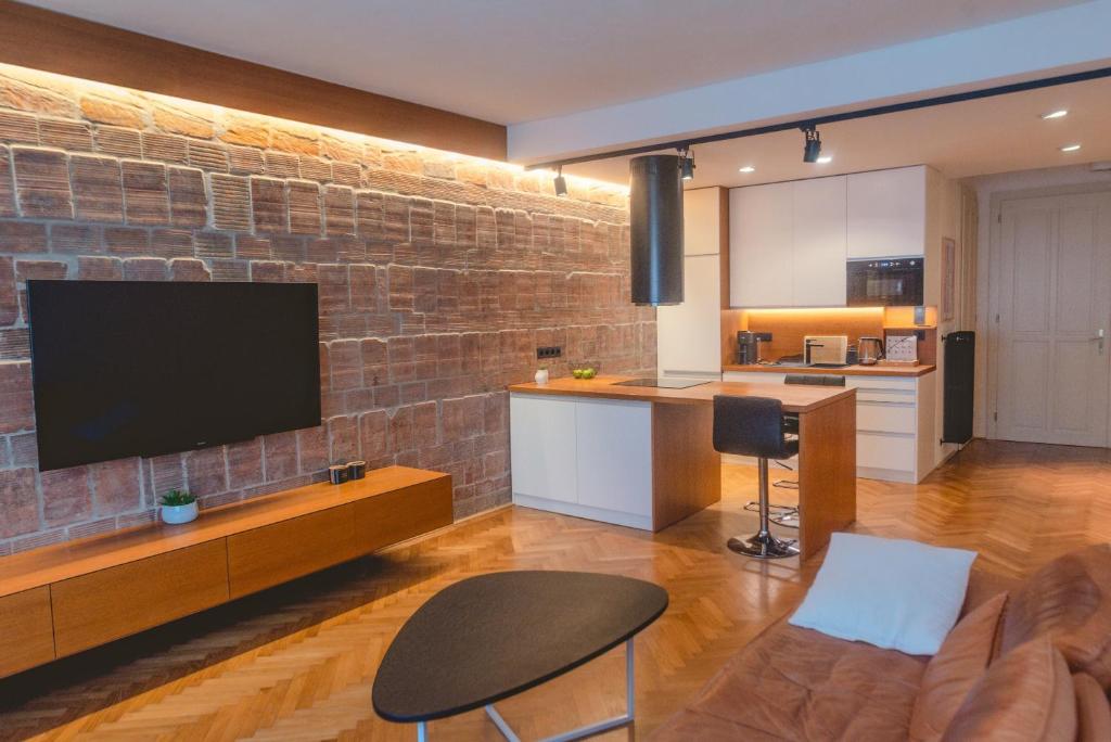 a living room with a tv on a brick wall at Luxury CITY CENTER APT w AC & Balcony in Bratislava