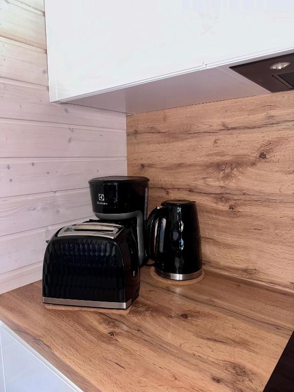 Countertop with black coffee maker, toaster, and kettle.