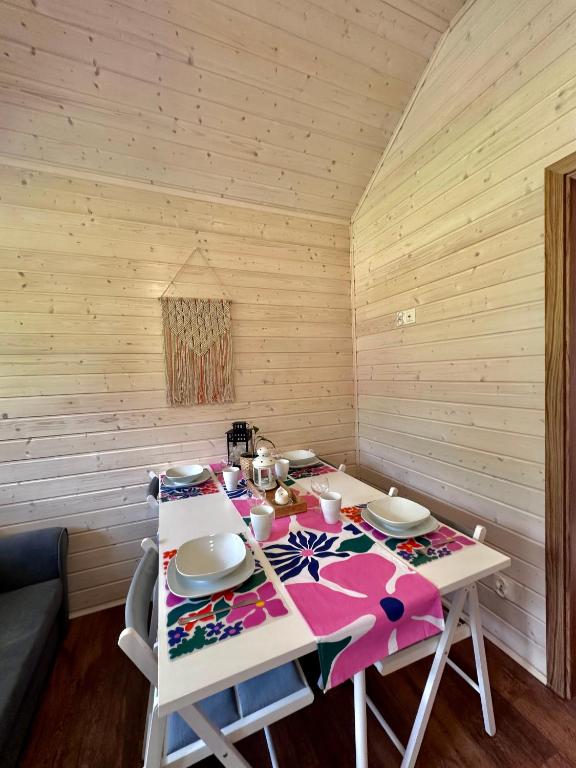 Wooden dining area with colorful table runner and set plates.