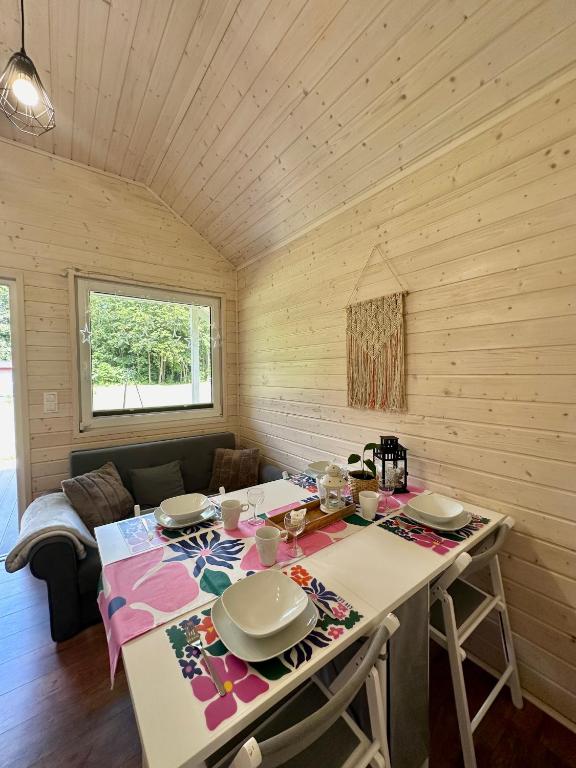 Cozy dining area with wooden walls, colorful tablecloth, and large window view.