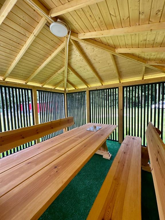 Wooden picnic table inside a covered pavilion with open sides.