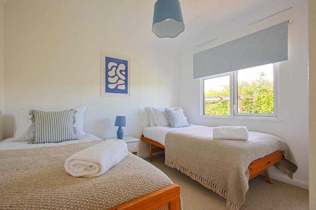 a bedroom with two beds and a window at Hot Tub With A View - Christchurch Harbour in Christchurch