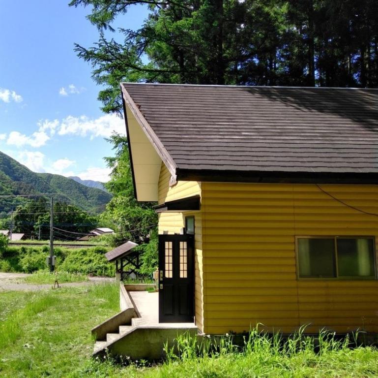 a small yellow house with a porch and stairs at Miyori Hometown Experience Village Campsite (Nakam - Vacation STAY 34965v in Nikko