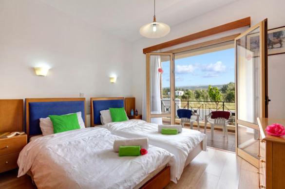 - une chambre avec un grand lit et une grande fenêtre dans l'établissement Akamas Bay View Villa, à Pólis Chrysochoús