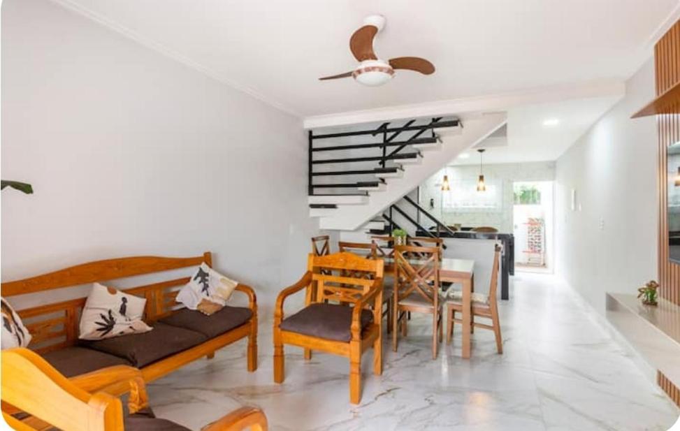 a living room with a couch and chairs and a table at Triplex Belíssimo in Cabo Frio