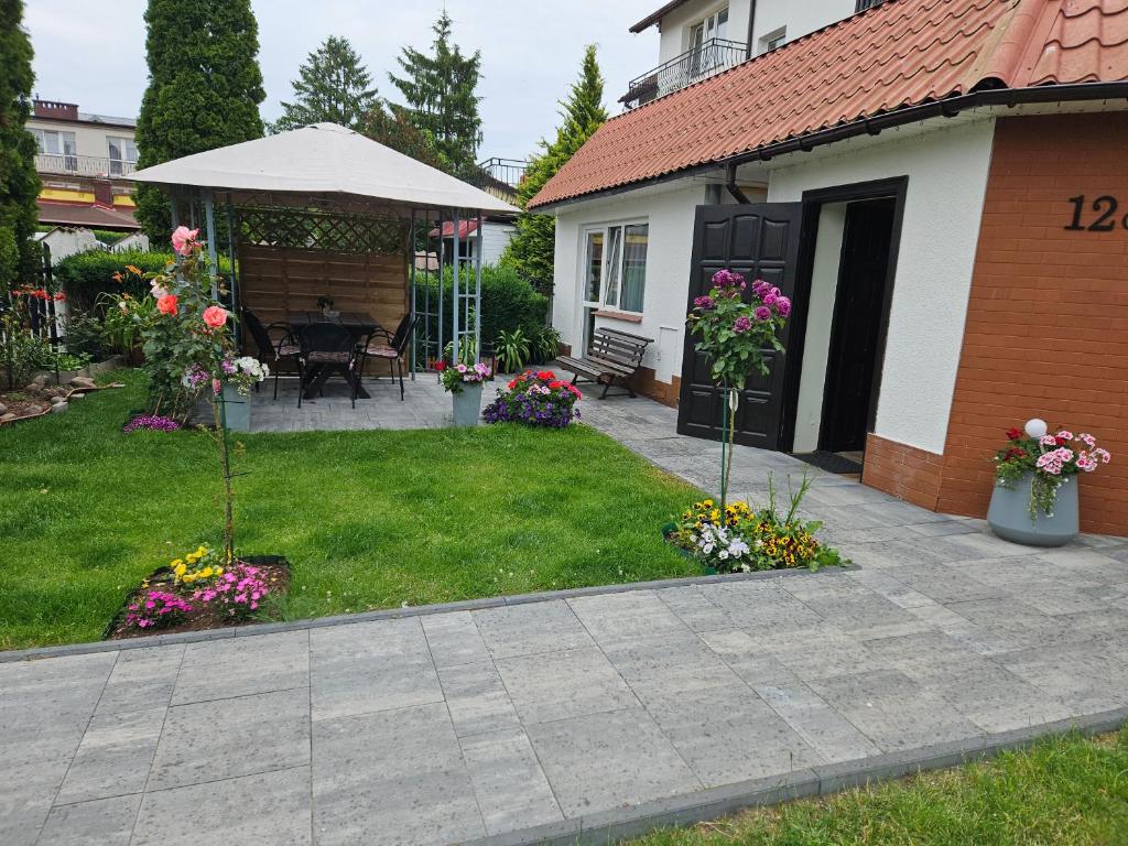 a yard with a house with flowers and a patio at Domki u Magdy in Ustka
