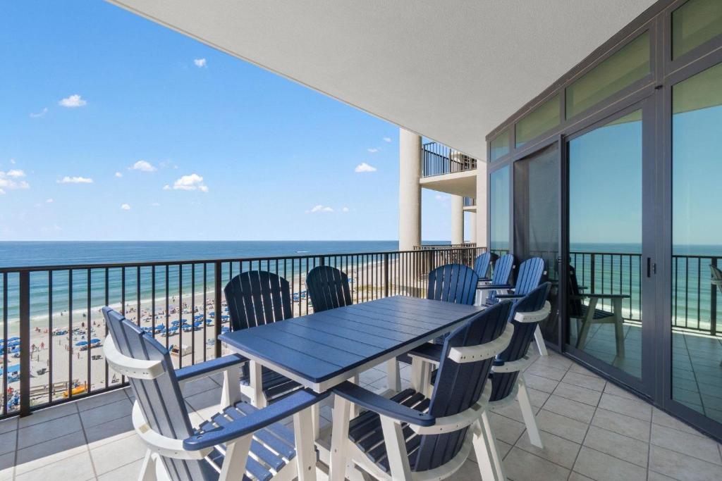 a dining table and chairs on a balcony with the beach at The Oasis at Orange Beach 609 (Phoenix West II) in Orange Beach