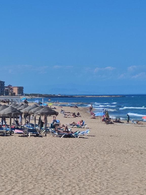 a group of people laying on a beach with umbrellas at Casa Marius in La Mata