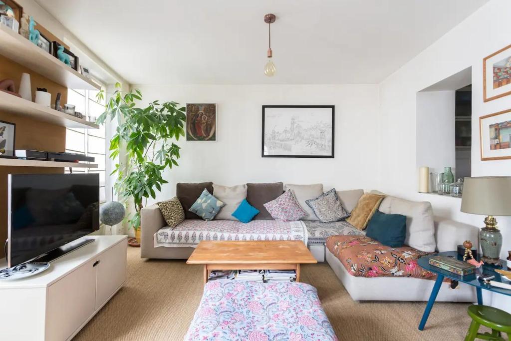 un salon avec un canapé et une table dans l'établissement Grand appart d'angle - Montmartre Moulin Galette, à Paris