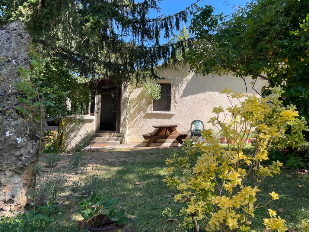 une maison avec une table de pique-nique dans la cour dans l'établissement La petite maison dans le jardin, à Bournazel