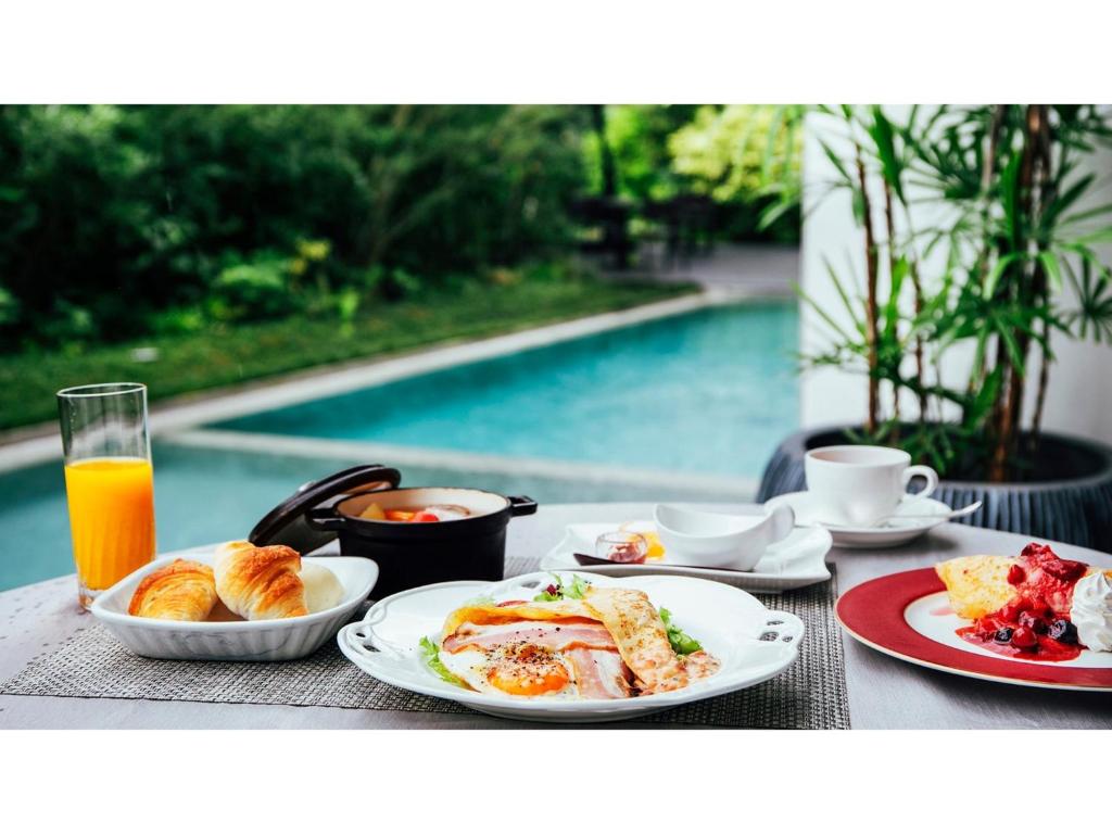 - une table avec des assiettes de petit-déjeuner et une piscine dans l'établissement Garden Terrace Saga Hotels & Resorts - Vacation STAY 29693v, à Saga